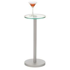 a glass table with a drink in it and a wine glass on the top that is half filled