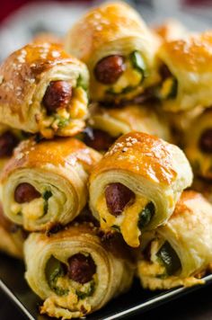 a plate filled with cheesy hot dogs wrapped in bread