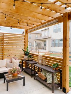 a covered patio with seating and potted plants