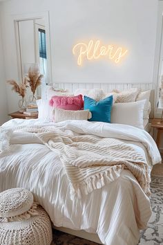 a white bed topped with pillows and blankets