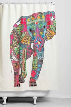 the shower curtain has an elephant painted on it's side and is decorated with colorful designs