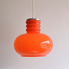 an orange light fixture hanging from a ceiling