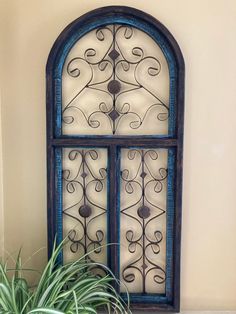 a potted plant sitting in front of a window with wrought iron work on it