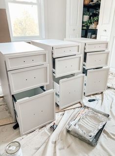 some drawers are being painted white in a room