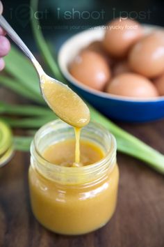 a person is spooning honey out of a jar