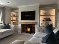 a living room filled with furniture and a fire place in front of a flat screen tv