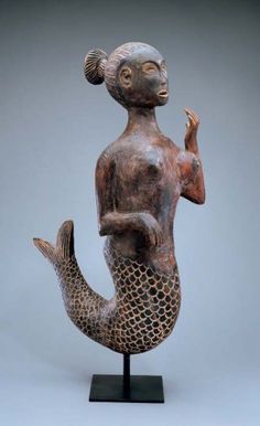 a statue of a woman sitting on top of a fish