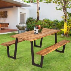 a wooden table with two benches in the grass