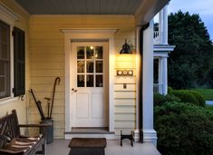 a porch with a bench and lamp on it