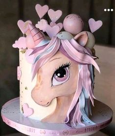 the cake is decorated with an image of a unicorn's head and hearts on it