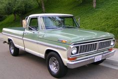 an old pick up truck is parked on the side of the road