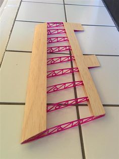 a piece of wood that has been cut into pieces with pink string attached to it