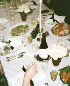 a dinner table is set with food and wine