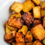 a white bowl filled with cooked cubed potatoes