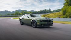 a green sports car driving down a road