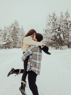 a man and woman hugging in the snow