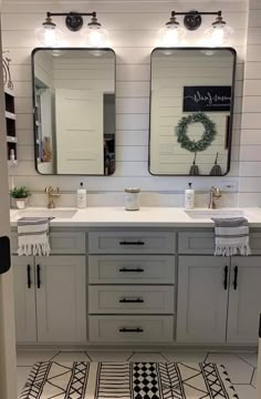 a bathroom with two sinks, mirrors and rugs on the floor in front of them