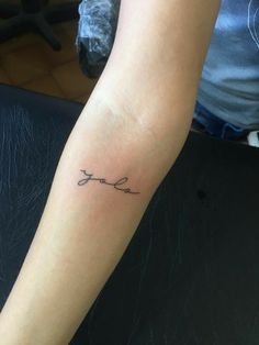 a woman's arm with a tattoo on it that says love in cursive writing