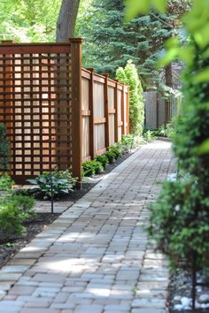 a brick walkway in the middle of a garden with trees and shrubbery on either side