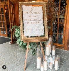 a sign that says welcome to our shears dinner with candles in front of it