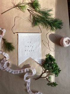 some pine branches and yarn on a table