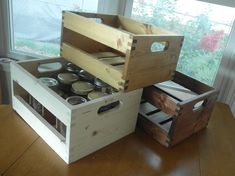 two wooden boxes with lids on them sitting on a table in front of a window