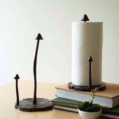 a couple of candles sitting on top of a wooden table next to books and a potted plant