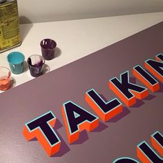 there is a sign that says talking out on the table next to some paint bottles