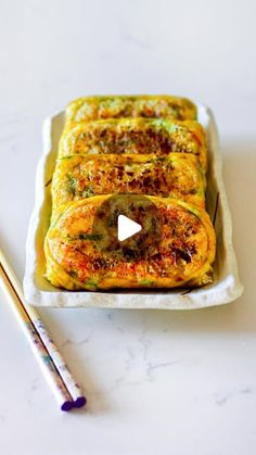 an omelet is sitting on a plate with two chopsticks next to it