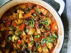 a pot filled with stew and vegetables on top of a table