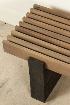 a wooden bench sitting on top of a cement floor