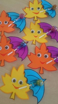 colorful paper cut outs with eyes and leaves on them are arranged in the shape of an umbrella