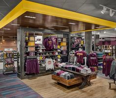 the inside of a sports store with purple and yellow shirts