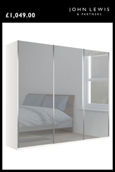 a white bedroom with mirrored closet doors and a bed