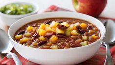 a white bowl filled with beans and apples