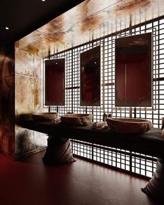 a bathroom with two sinks and mirrors on the wall next to each other in front of a red light