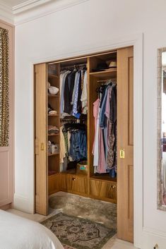 an open closet with clothes hanging in it