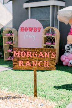 a wooden sign that says morgan's ranch in front of some balloons and decorations