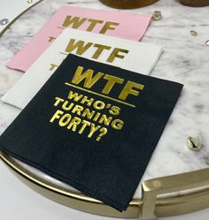 a black napkin with gold foil on it sitting on top of a white marble table