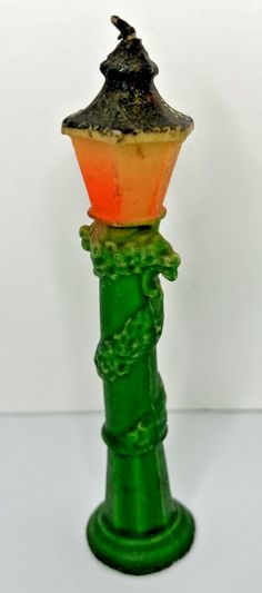 a green and orange candle holder on a white surface