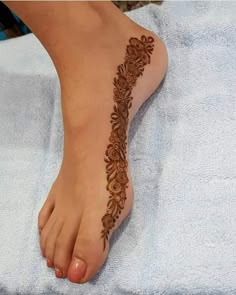 a woman's foot with a henna tattoo on it