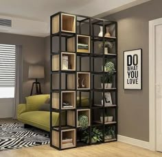 a living room filled with lots of bookshelves next to a green couch and zebra print rug