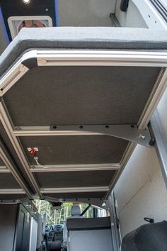 the inside of an rv with its door open and seats down, looking up at the ceiling