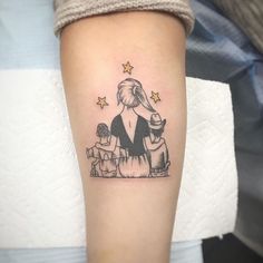 a woman's arm with a small tattoo of an elephant and two children on it