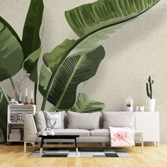 a living room scene with a couch and large green plant wall mural on the wall