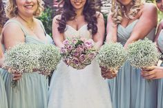 a group of women standing next to each other holding bouquets