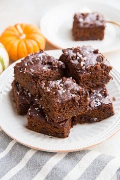 some brownies are on a plate with pumpkins in the backgroung