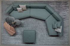 an overhead view of a modern living room with blue couches and grey rugs