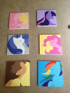 four different colored paintings on the floor with one being a cat and two are unicorns