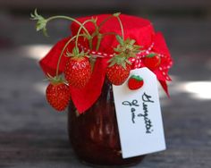 a jar with some strawberries in it and a price tag attached to the top